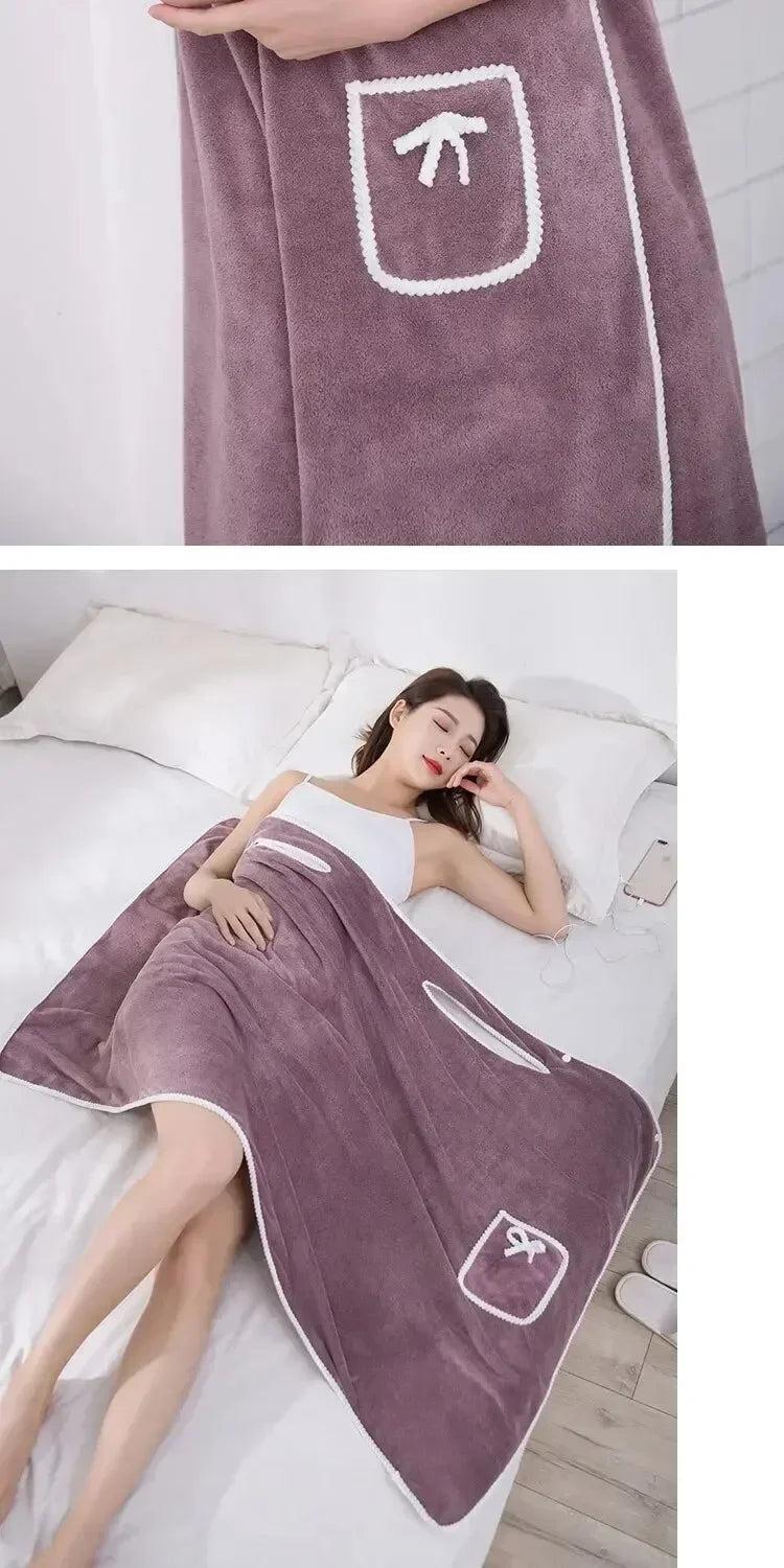 A woman wearing a purple fleece bath robe is relaxing on a bed.