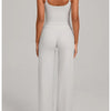 A woman models a light gray high-waist yoga and fitness tracksuit set top and pants.