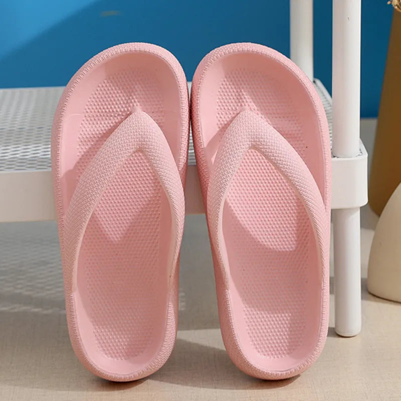 A pair of pink comfort platform flip flops resting on a white surface.