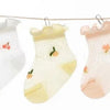 A pack of five thin summer casual baby socks in various pastel pink and white colors hanging on a line.