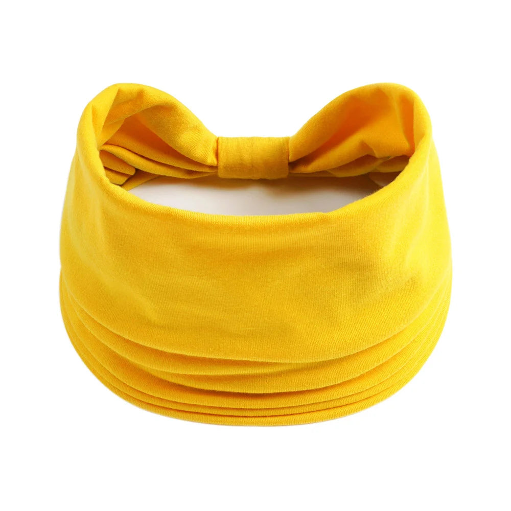 Un foulard en coton bohème jaune vif noué en nœud.