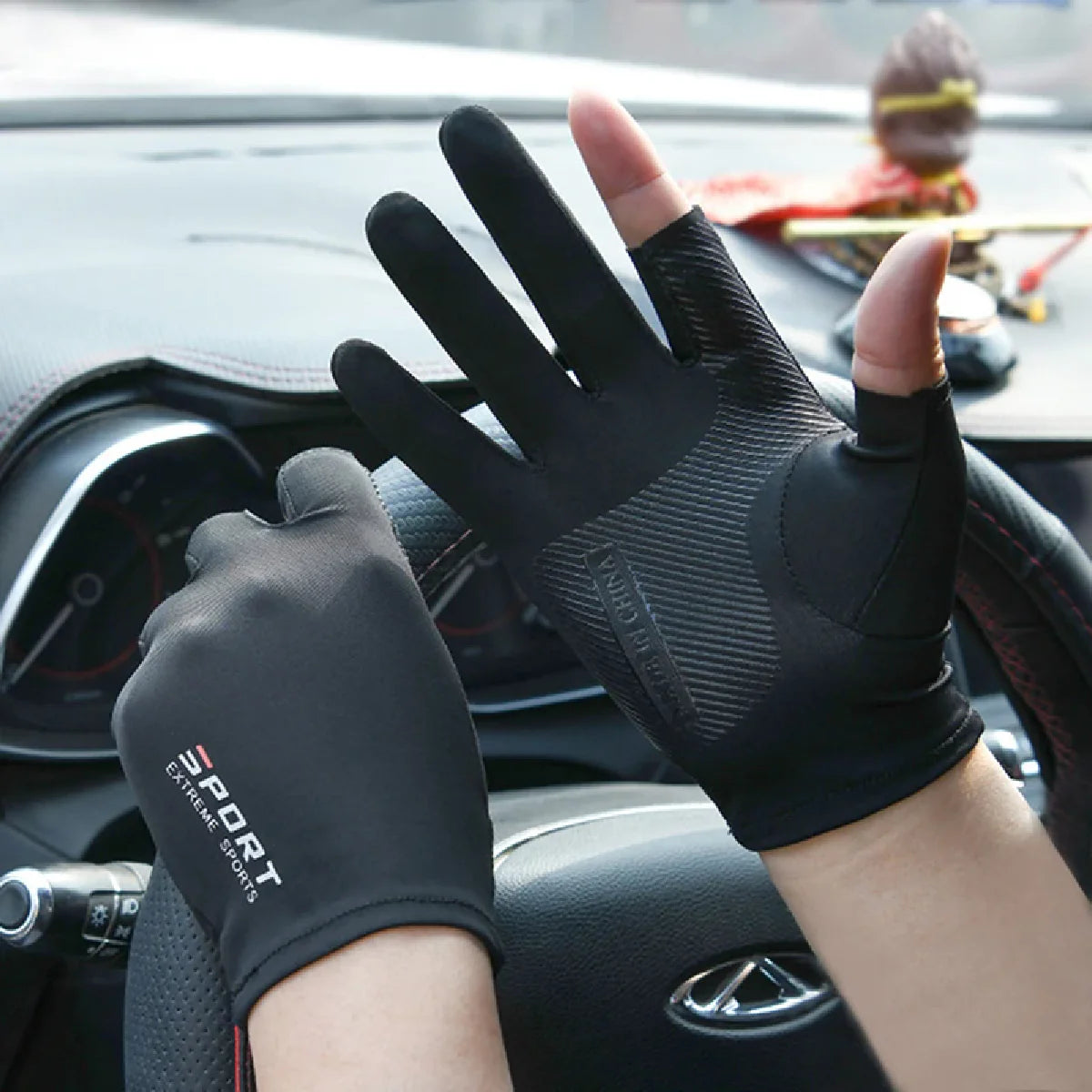 Eine Hand mit schwarzen Sport- und Rennhandschuhen ist im Auto, nahe dem Lenkrad, sichtbar.