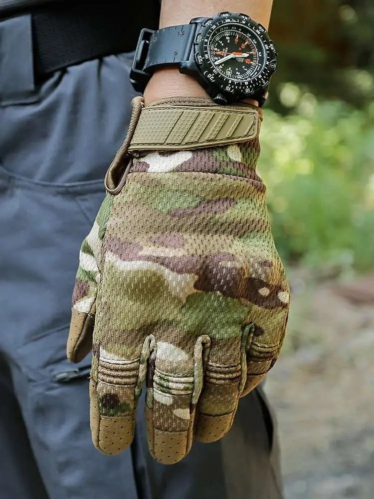 Une main portant des gants tactiques camouflage et une montre noire, tenue contre un fond sombre.