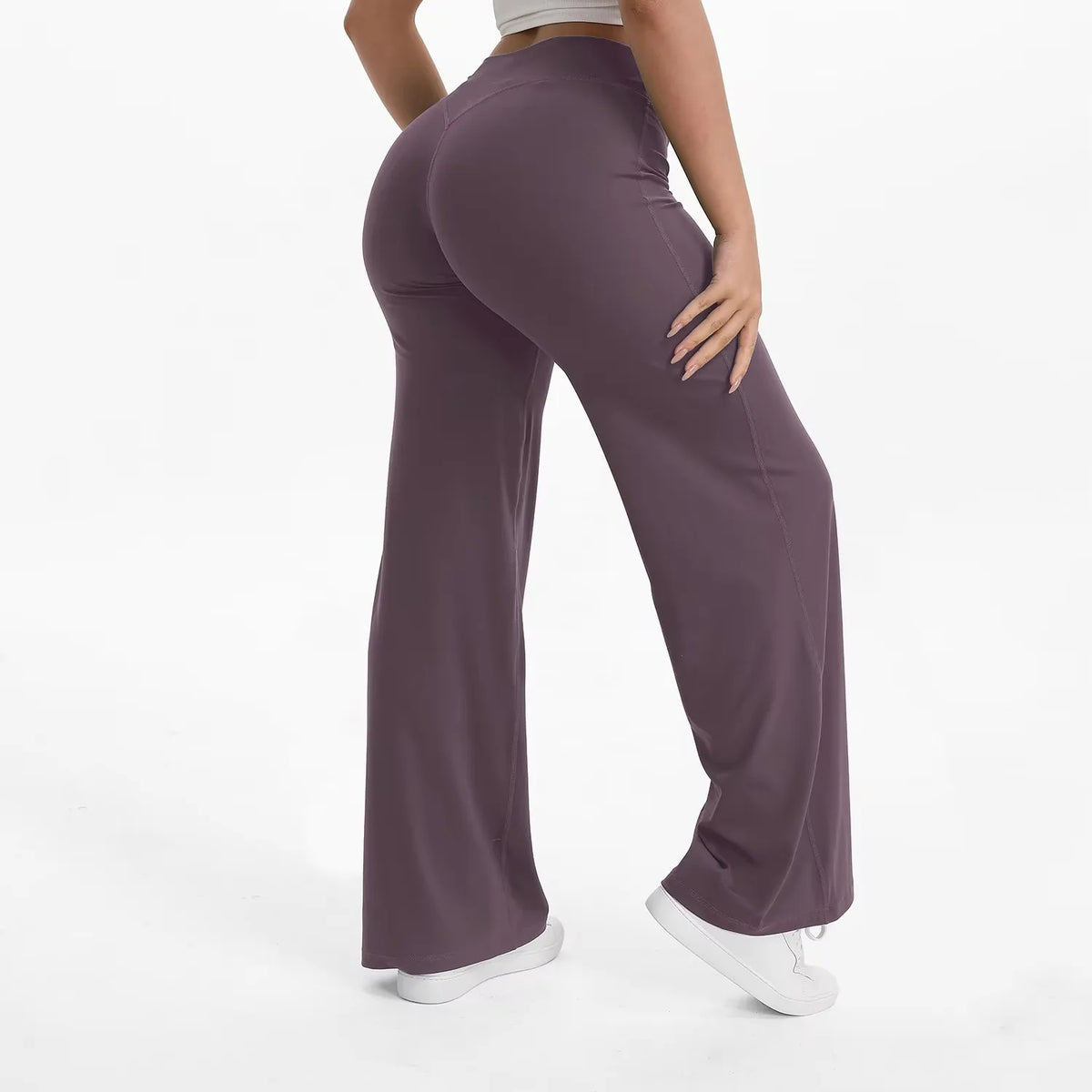 A person is modeling high-waist yoga pants in a deep purple color.
