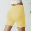 Une femme portant un short de yoga sans couture jaune taille haute et un haut blanc.