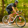 Ein Fahrradfahrer mit Sonnenbrille und Helm fährt ein Fahrrad auf der Straße, unterstützt durch eine verstellbare Kompression