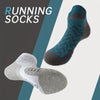 A pair of blue and gray performance ankle socks are shown against a dark background.