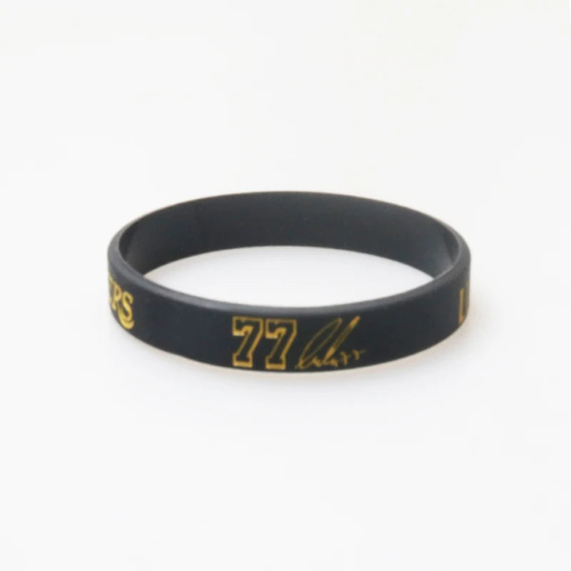 Black silicone wristband with gold lettering displaying 77 and a logo.