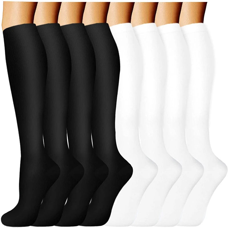 A display of black and white compression socks for vein support, shown from the ankle up.