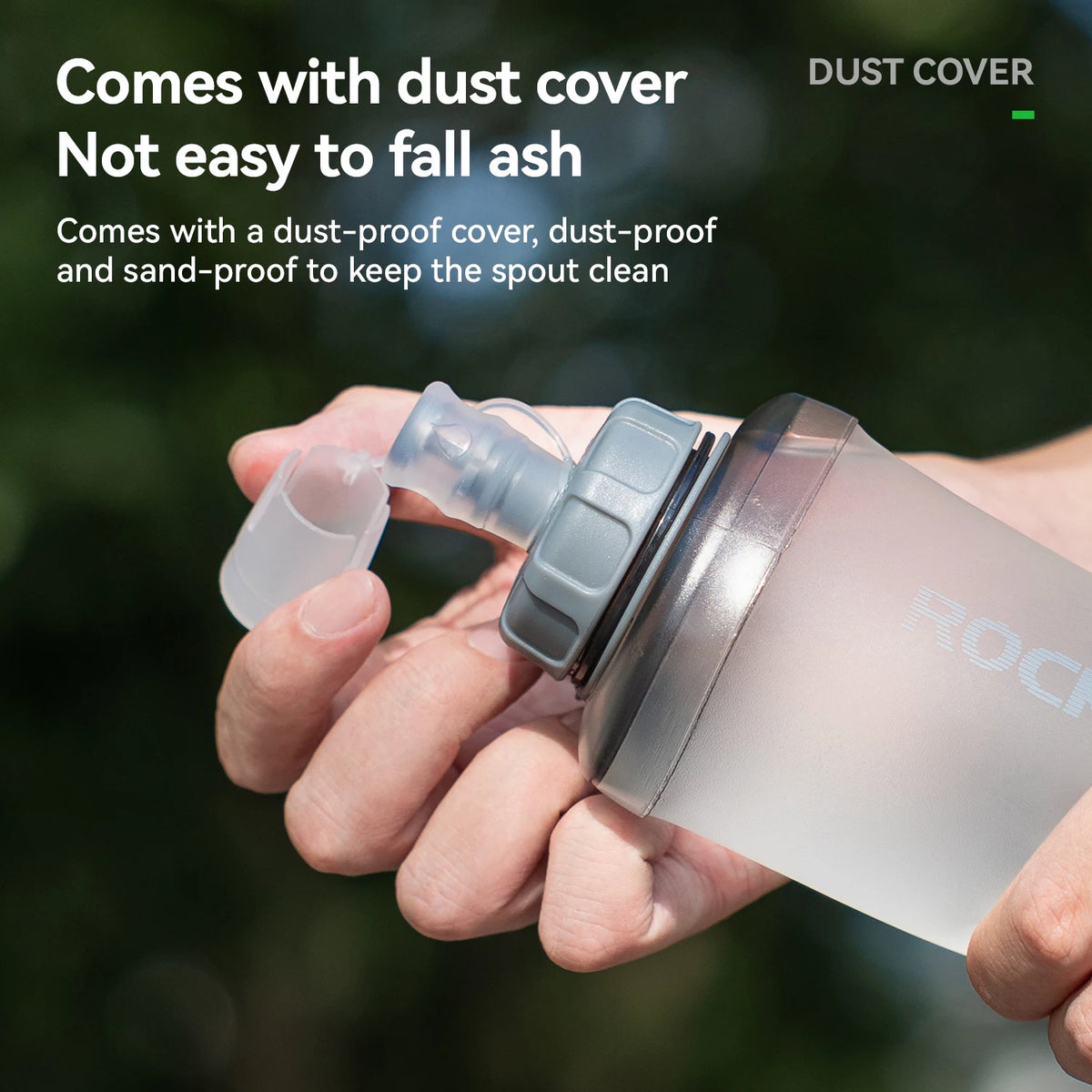 Una mano sostiene una botella deportiva de silicona transparente con tapa y pico, mostrando sus características.