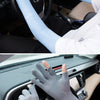 A person wearing light blue UV protection arm sleeves is shown in the driver's seat of a car.