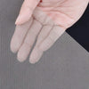 Une main tient des gants à mailles de fil beige clair contre un fond de mailles métalliques argentées.