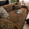 A plush sofa covered in a leopard print fabric, featuring dark brown and black spots.
