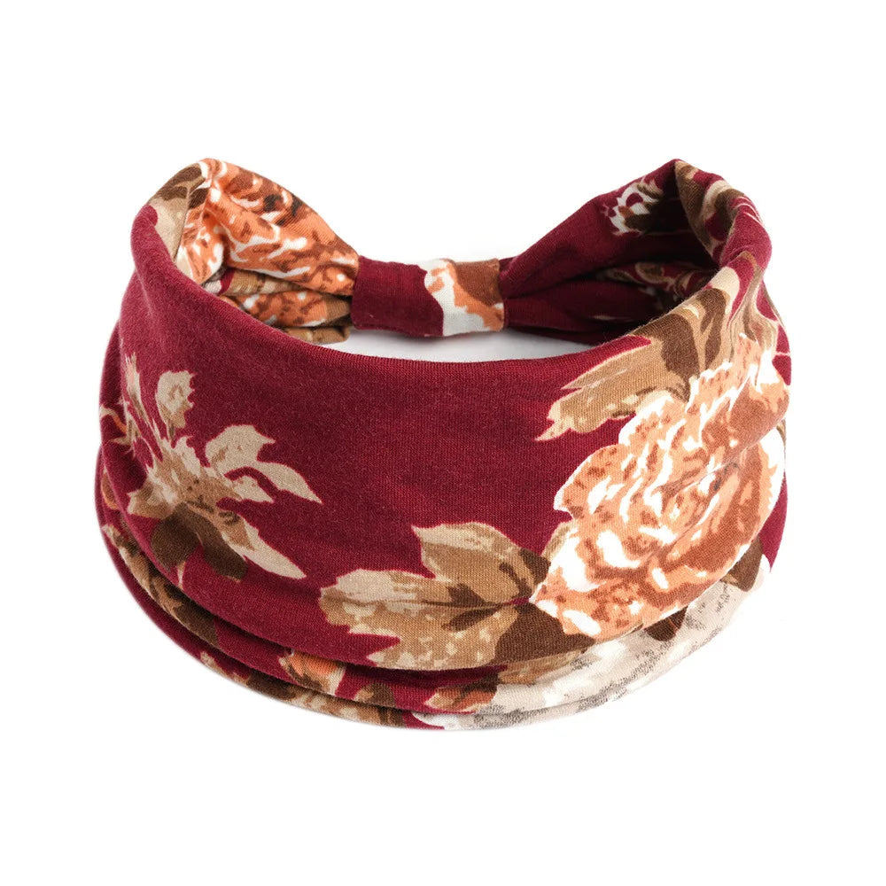 A maroon floral patterned cotton stretch headband tied in a bow.