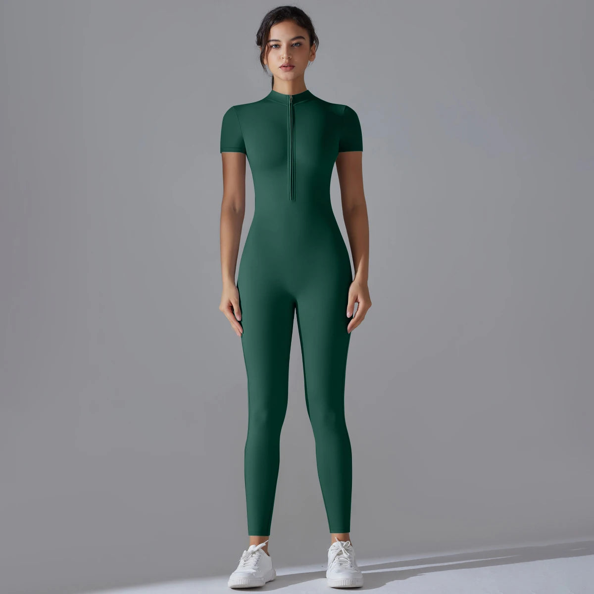A model wearing a dark green Naked Zipper Yoga Jumpsuit standing against a plain gray background.