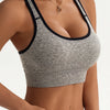 A model wearing a gray seamless racerback sports bra top and matching bottoms.