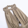A close-up of a sage green maxi dress with a draped cut-out neckline and gathered fabric detail.