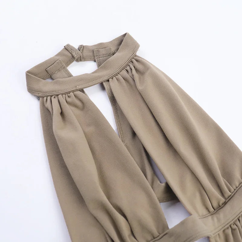 A close-up of a sage green maxi dress with a draped cut-out neckline and gathered fabric detail.