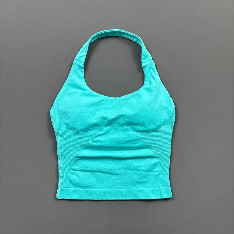 A bright turquoise seamless performance yoga and gym tank top displayed against a gray background.