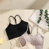 A collection of ribbed crop tops in purple, beige, and black laid out on a light surface.