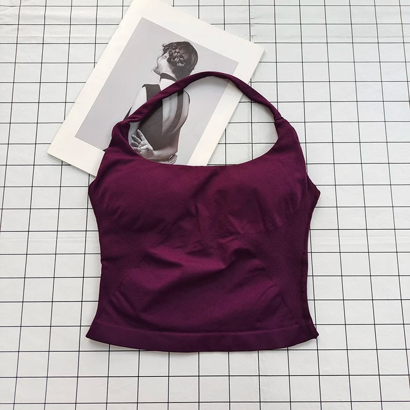 A deep purple seamless sports camisole top laid on a white grid background next to a photo.