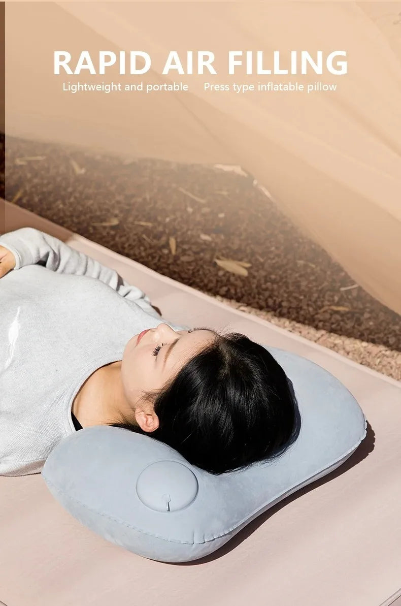 A person is using a light blue inflatable pillow for neck and lumbar support while lying down.