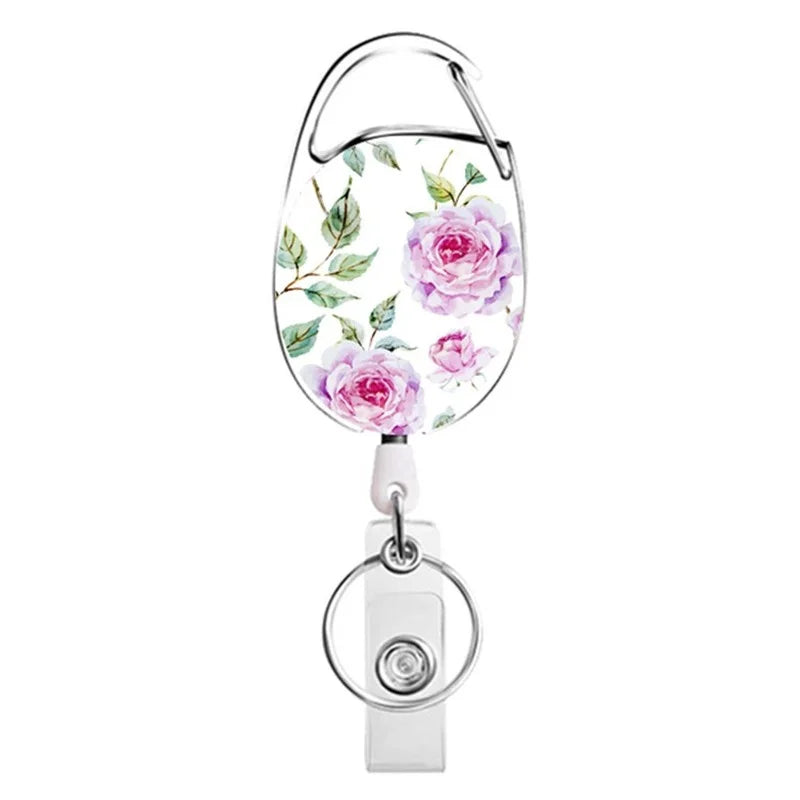 A silver retractable ID badge reel keychain featuring a floral pattern on the badge holder.