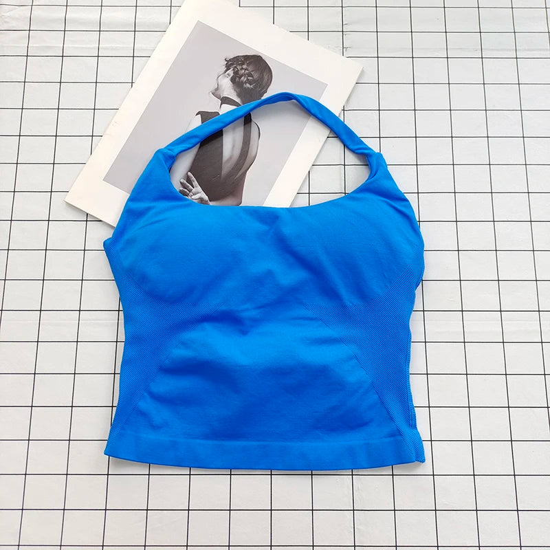 A bright blue seamless sports camisole top laid on a grid background next to a photo.