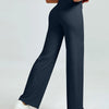 A woman is modeling dark navy high waisted yoga pants with white sneakers.