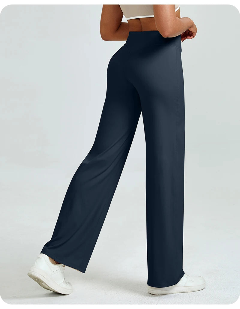 A woman is modeling dark navy high waisted yoga pants with white sneakers.