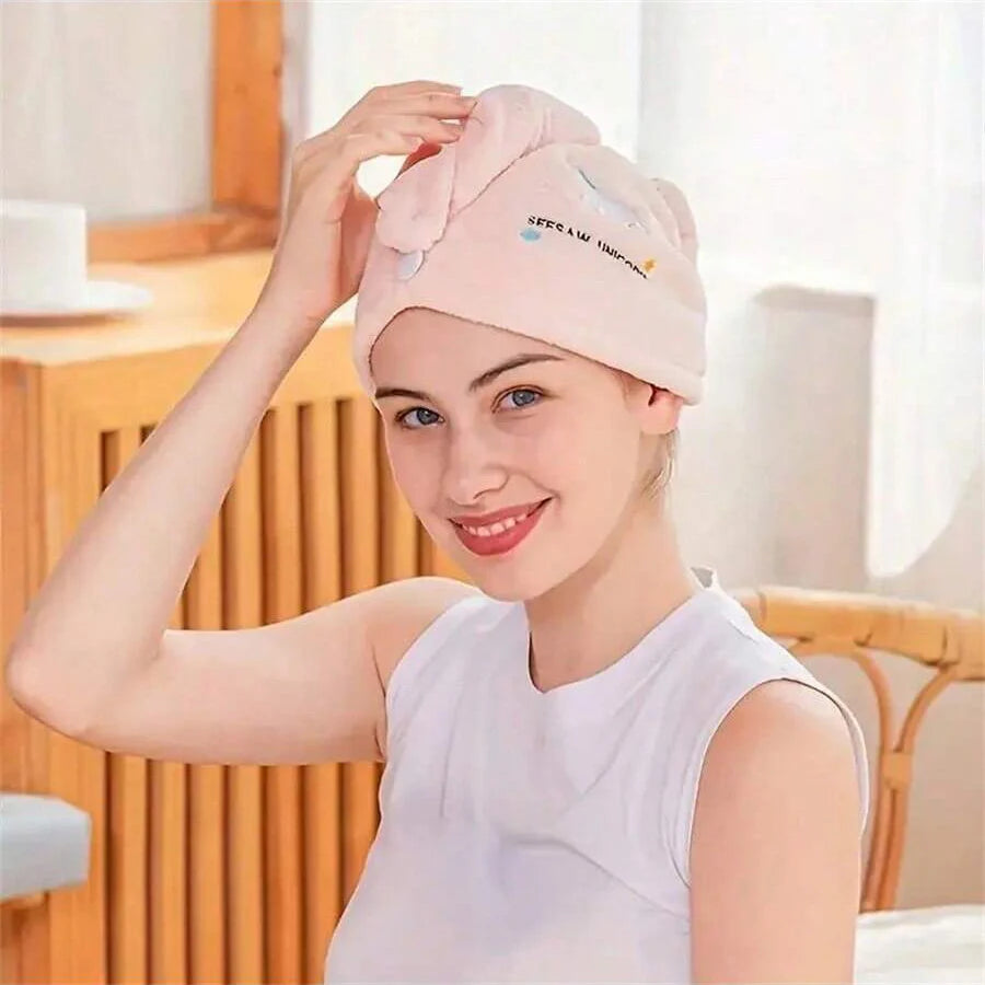Eine junge Frau trägt eine rosa Stickerei-Haartrockenhaube drinnen.