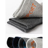 A stack of gray and dark gray men's sport compression socks rolled up for display.