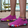 A pair of bright purple waterproof quick-dry outdoor hiking shoes resting on a wooden deck.