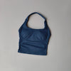 Haut sans coutures bleu marine à col, pour yoga et fitness, sur fond gris clair.