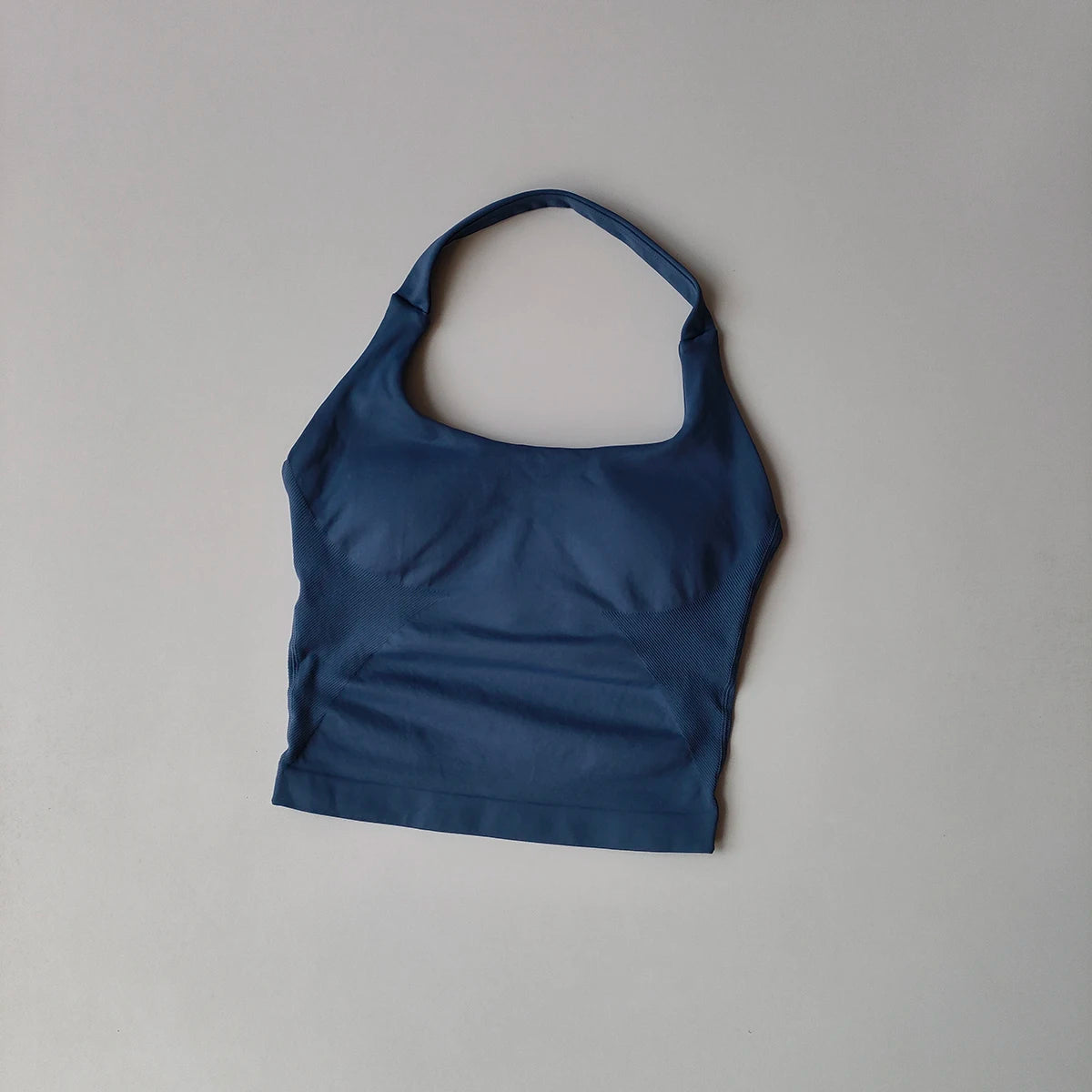 Haut sans coutures bleu marine à col, pour yoga et fitness, sur fond gris clair.