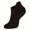 Black grip Pilates socks shown from the side, highlighting the textured sole.