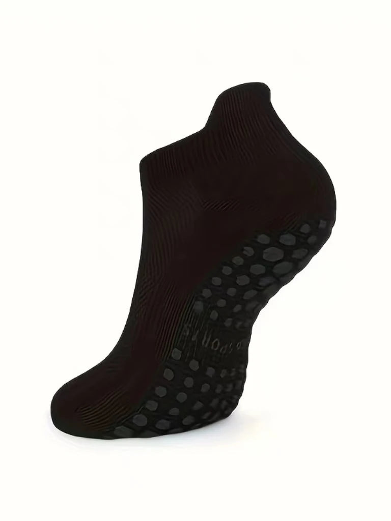 Black grip Pilates socks shown from the side, highlighting the textured sole.