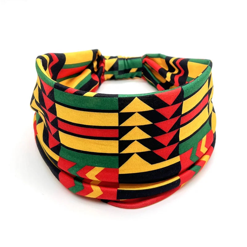 A colorful bohemian stretch cotton headband featuring geometric patterns in yellow, green, red, and black stripes.