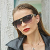 A close-up of a woman wearing classic retro square sunglasses and a leather jacket.