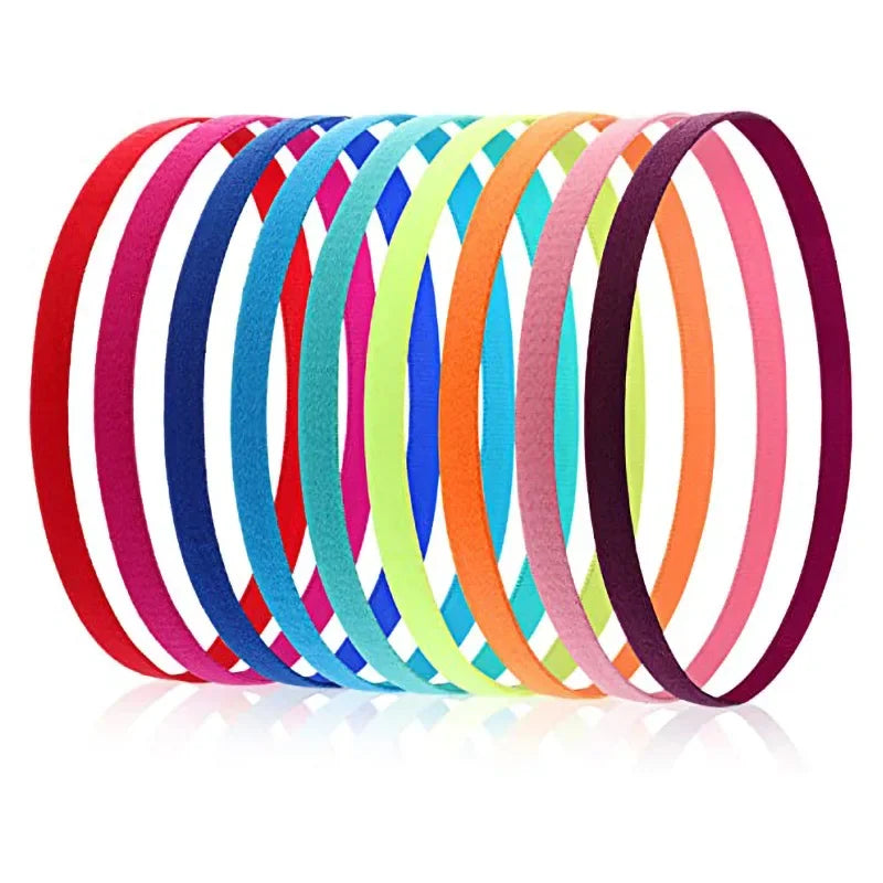 A stack of five colorful silicone elastic sports headbands in various shades of pink, blue, green, and orange.