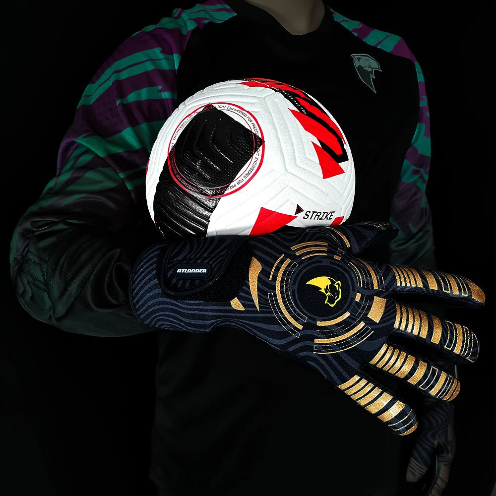 A hand wearing black goalkeeper gloves holds a white and red soccer ball against a dark background.