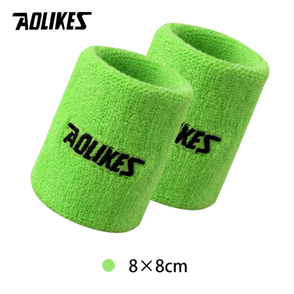 A pair of bright lime green knitted sport wristbands shown against a white background.
