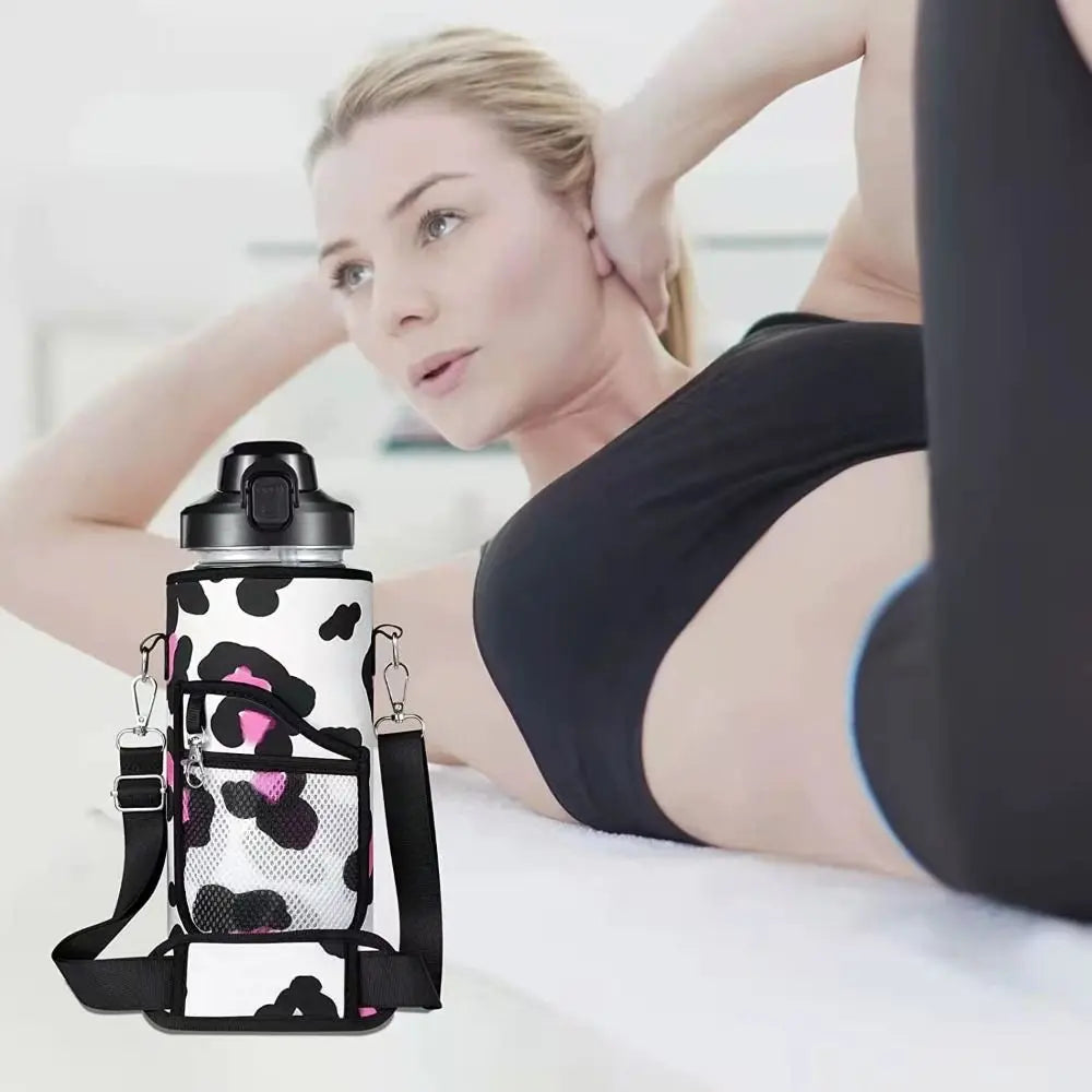 A woman is holding an insulated water bottle cover with a leopard print design and adjustable strap.
