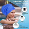 A woman wearing a blue silicone swimming cap, demonstrating how to put it on for hair protection.