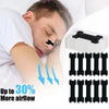 A person is applying black hypoallergenic nasal strips to their nose for congestion relief.