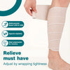 A hand is applying a beige elastic compression wrap to a person's lower leg.
