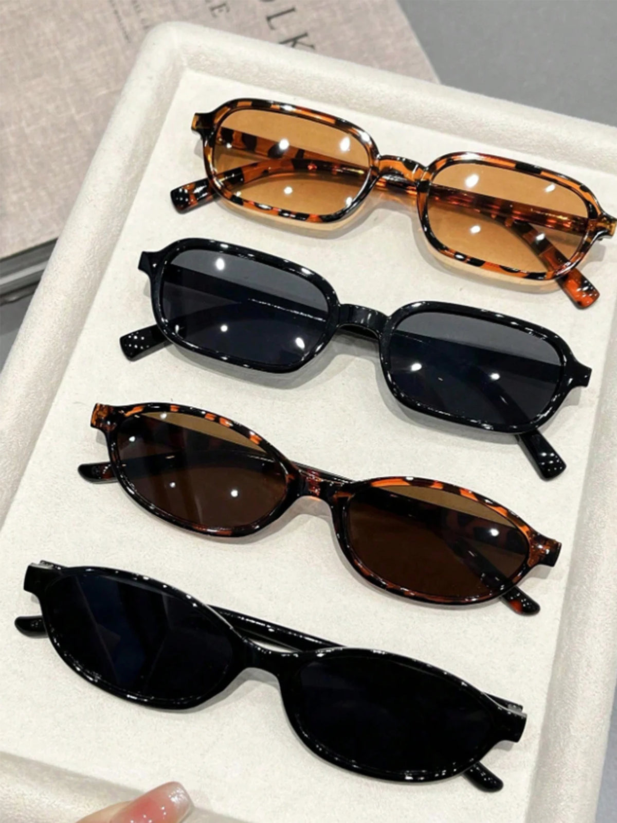 A set of five retro fashion sunglasses with various brown and black tinted lenses and frames displayed in a white box.