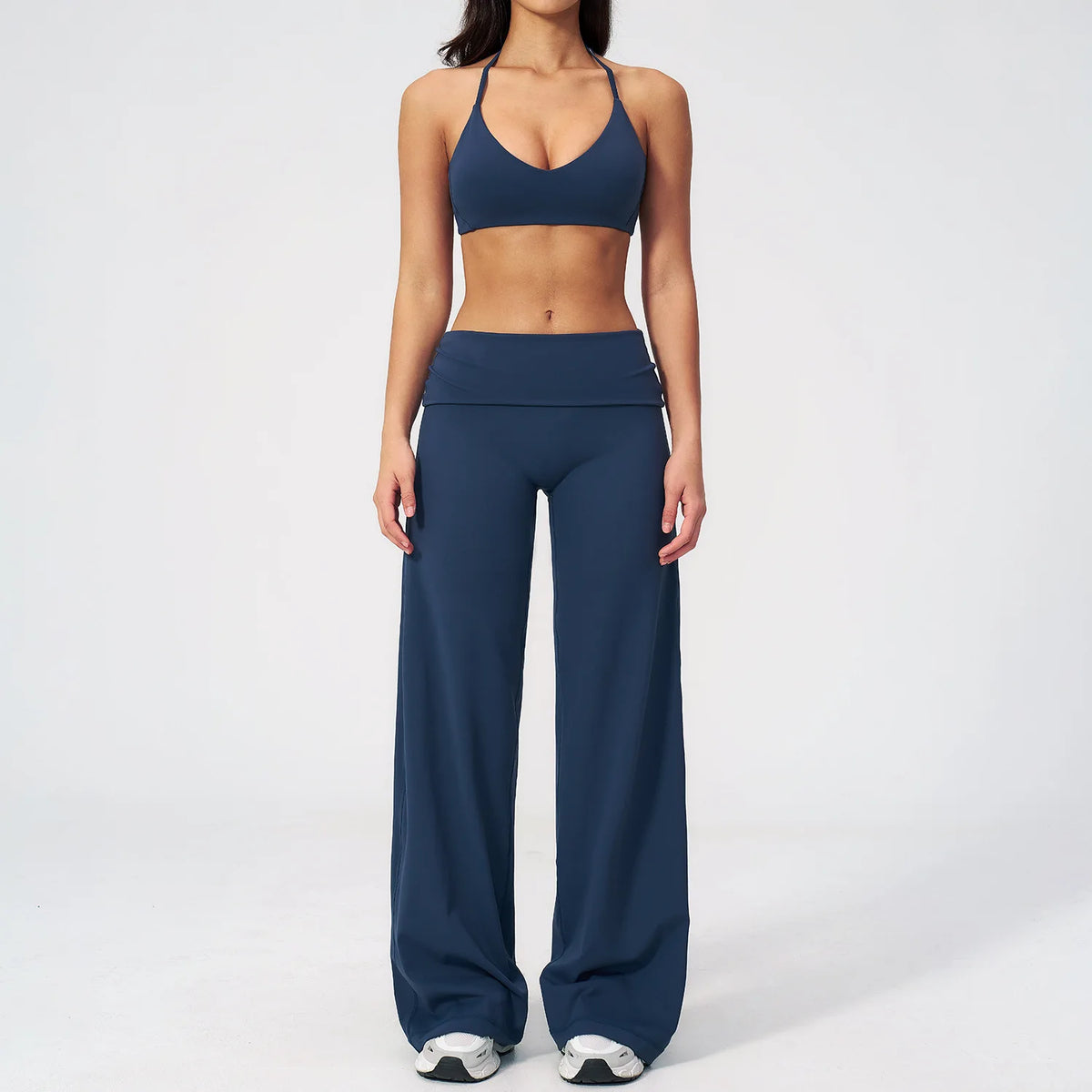 A woman wearing a navy blue women's premium fitness tracksuit top and matching pants.