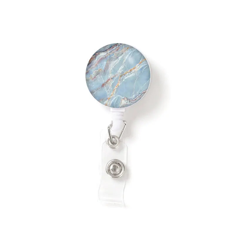 A round piece of blue and white marble stone attached to a clear plastic keychain.