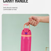 A hand is holding a bright pink insulated thermos mug with an integrated carry handle.